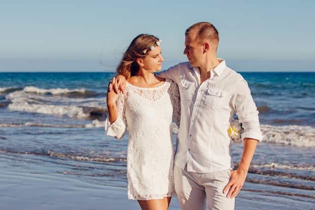 man and woman hugging and walking on the seaside